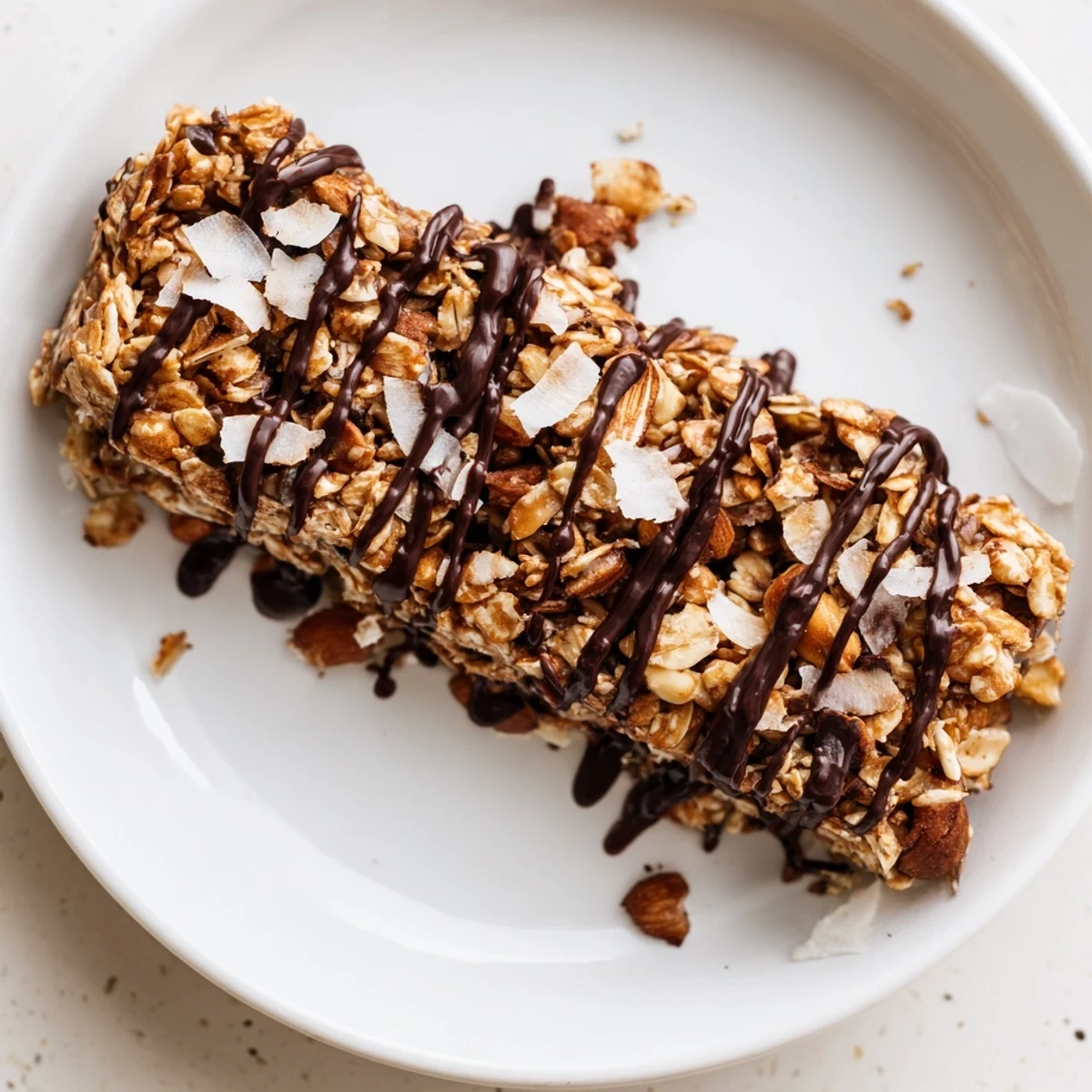 Freshly cut Chocolate Snack Bars show melted dark chocolate drizzle over oats and nuts on a wooden board.