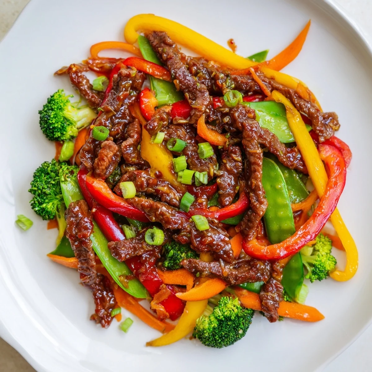 Tender beef strips sizzling in a wok with onions and carrots for Spicy Beef Stir Fry with Mixed Vegetables.