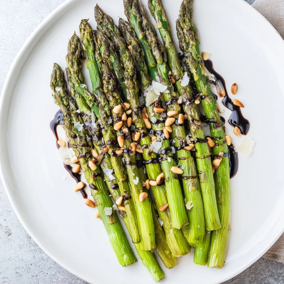 Roasted asparagus with balsamic reduction served warm beside grilled chicken for an elegant dinner.