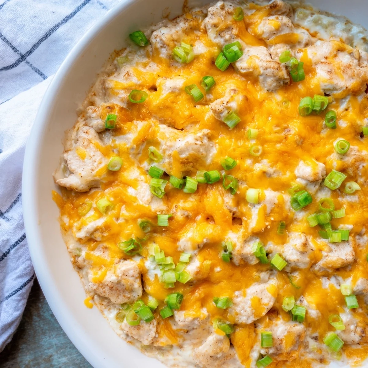 Comforting Sour Cream and Onion Chicken bake paired with steamed broccoli and fluffy mashed potatoes on a white plate.