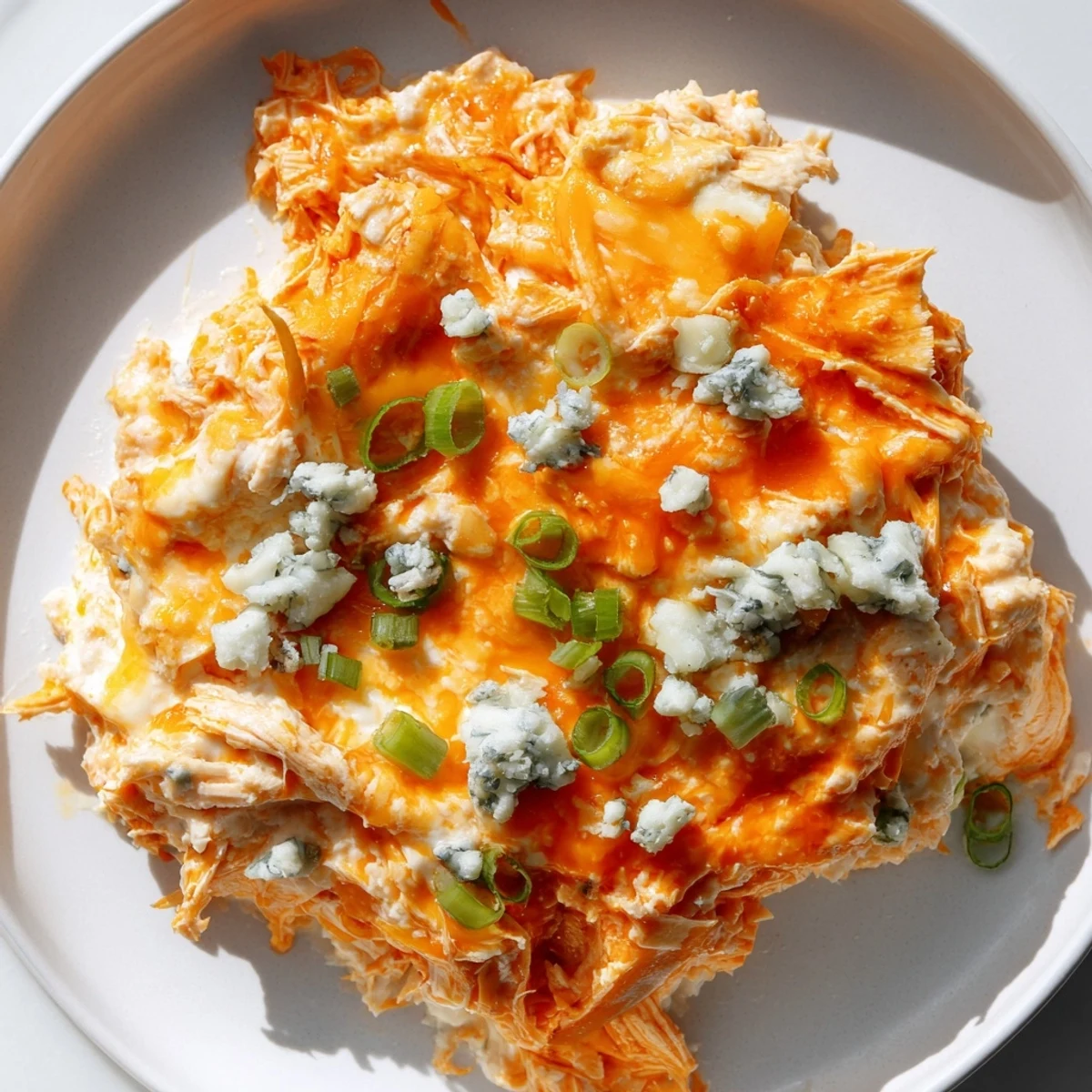 Appetizer platter of Keto Buffalo Chicken Dip surrounded by fresh celery, cucumber slices, and keto-friendly low carb crackers.