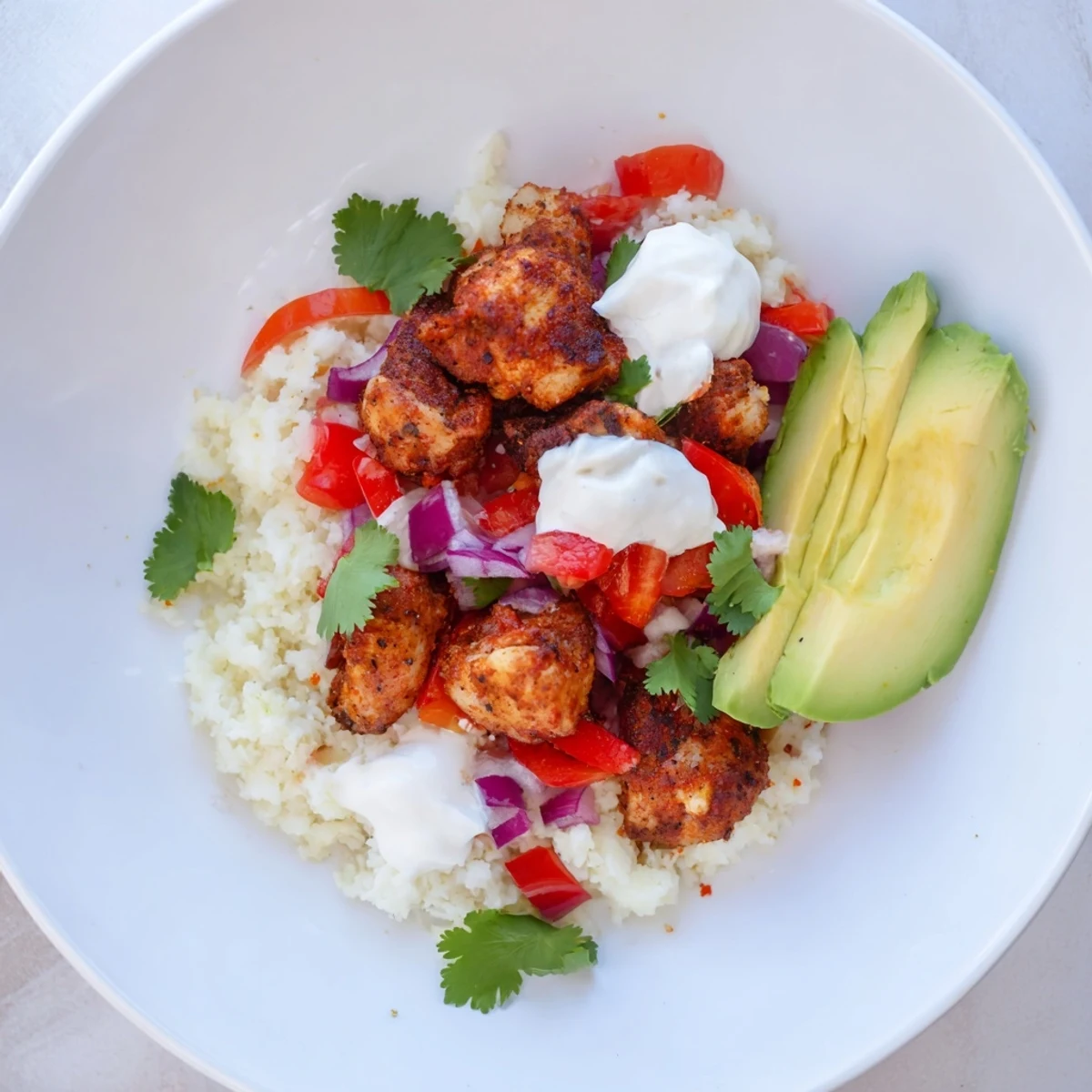 Colorful diced vegetables and melted cheese cover the Low Carb Burrito Bowl ready for a healthy family dinner.