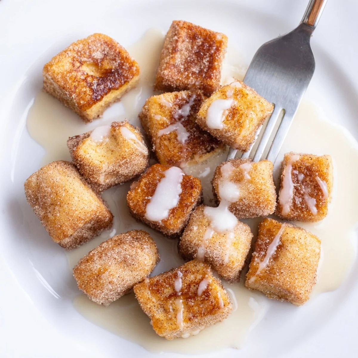 Warm, bite-sized Cinnamon Roll French Toast Bites served with a side of fresh berries and cream.
