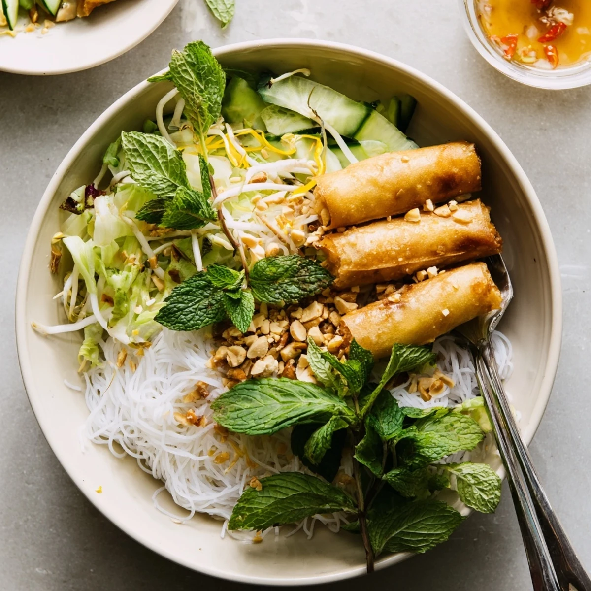 Steamed Bun Cha Gio featuring golden cha gio nestled on cool noodles, bean sprouts, cucumber, and mint for dinner.