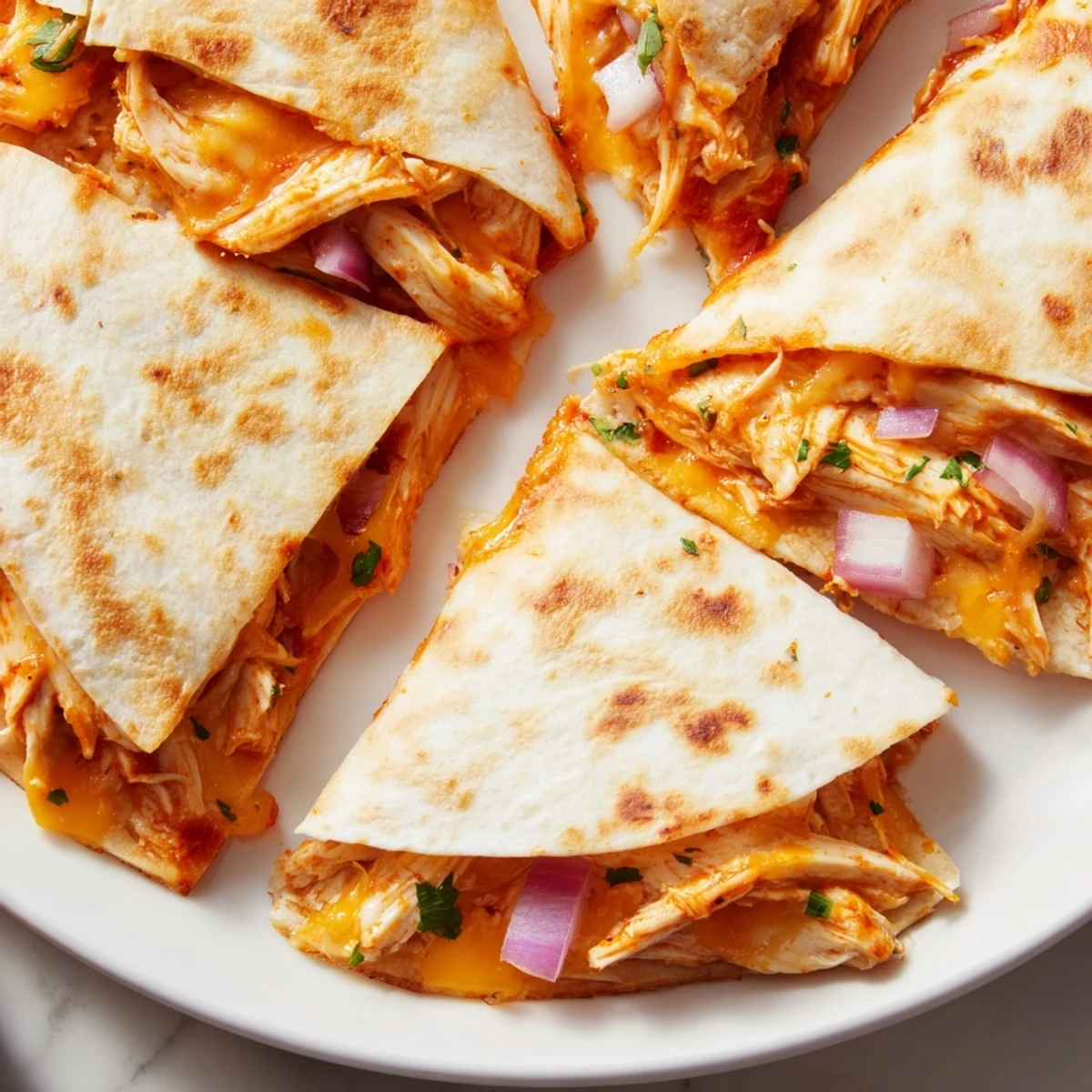 Sizzling Hot Honey BBQ Chicken Quesadillas served with sour cream and lime wedges.