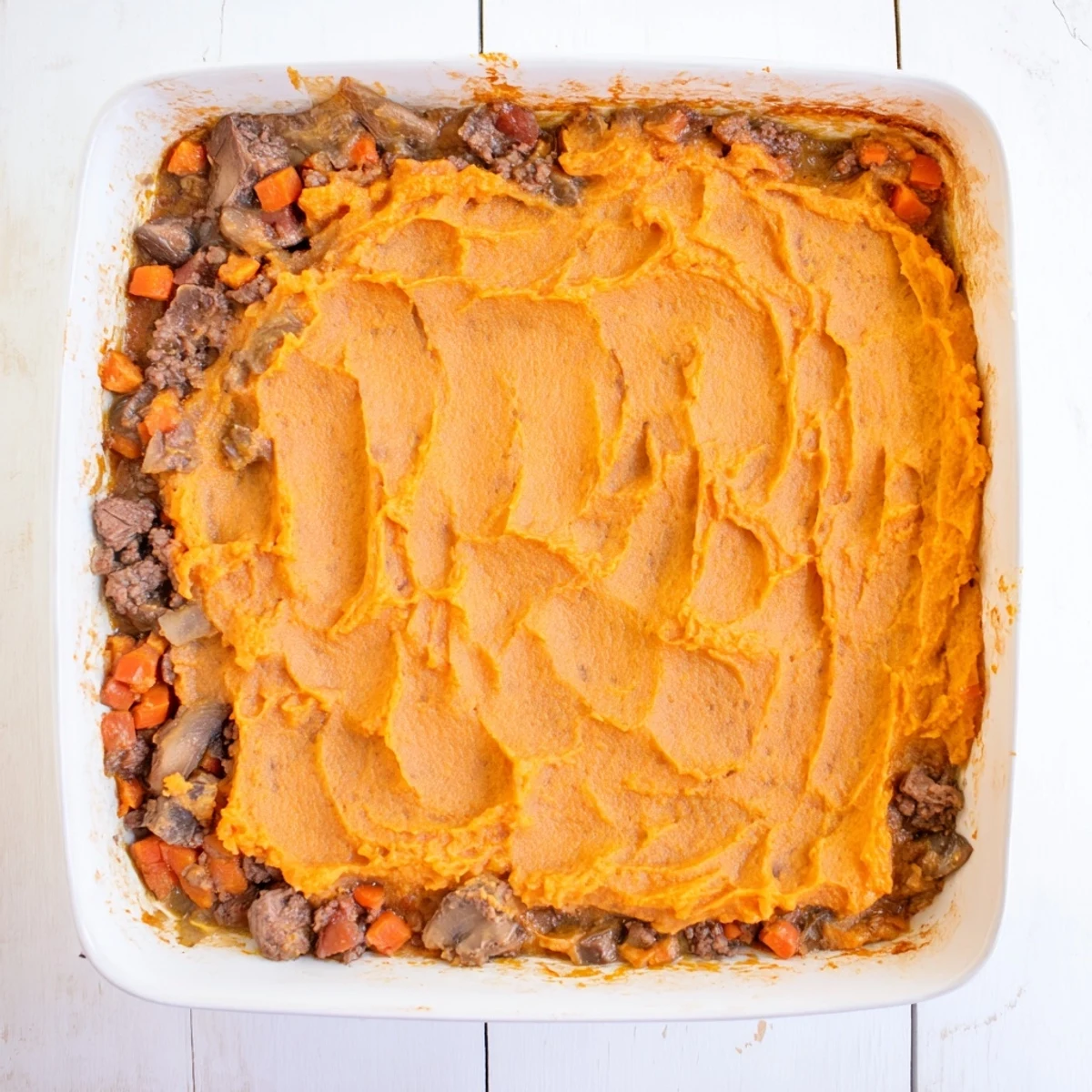 Golden brown sweet potato mash tops a bubbling Beef, Tomato & Mushroom Cottage Pie filling, showcasing savory aromas.