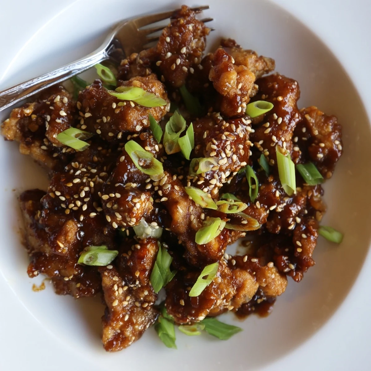 Golden crispy Mongolian chicken pieces coated in a glossy sweet savory soy ginger sauce