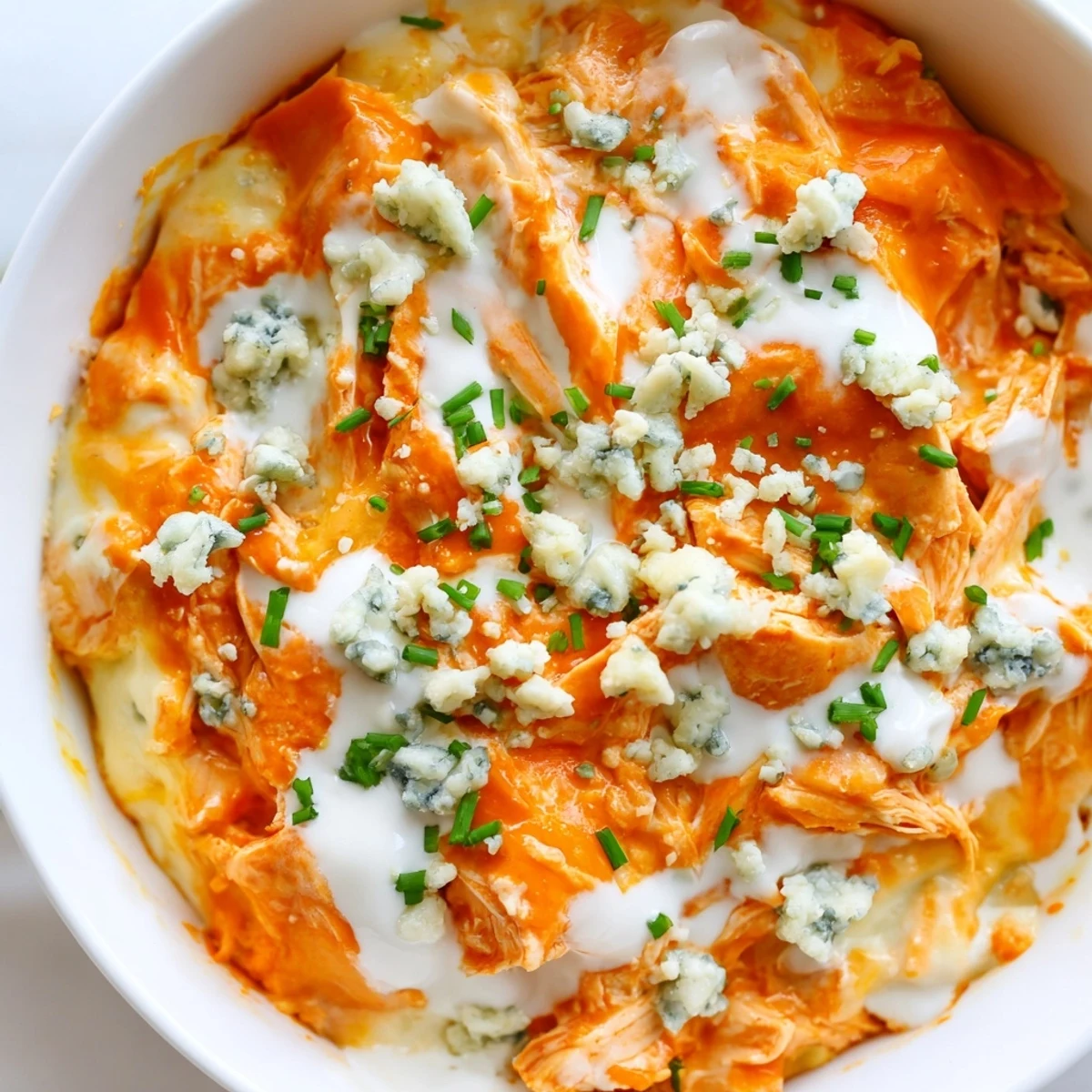 Steaming slow cooker Buffalo Chicken Dip with shredded chicken and ranch ready for dipping