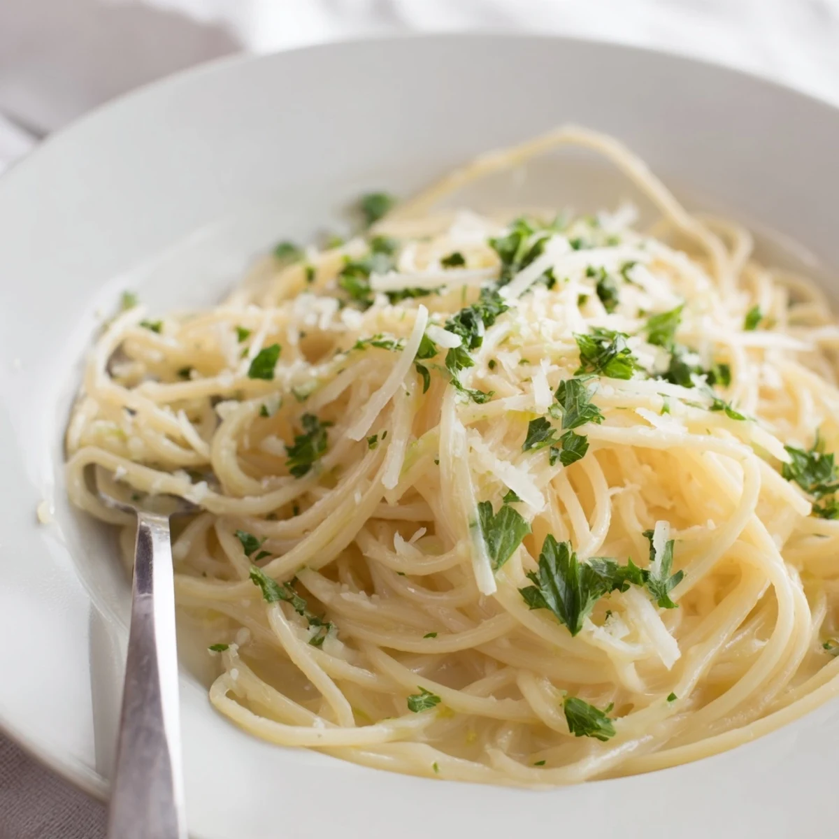 Golden strands of one pot garlic butter pasta coated in creamy parmesan sauce with fresh parsley