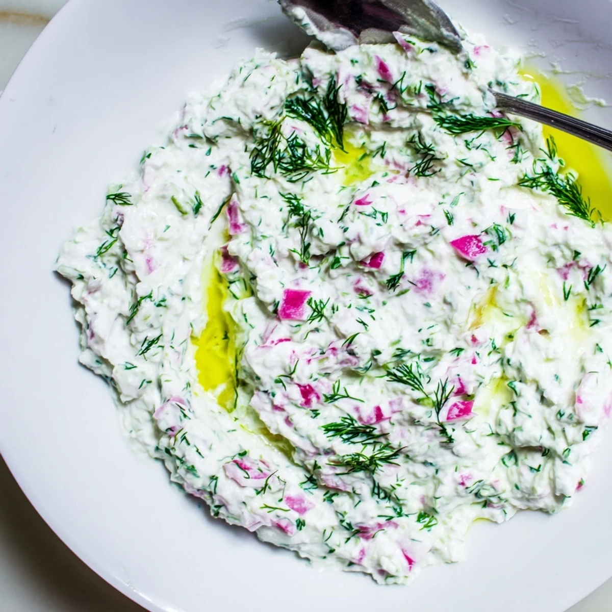 Vibrant healthy radish tzatziki dip served in bowl with crisp vegetable crudités