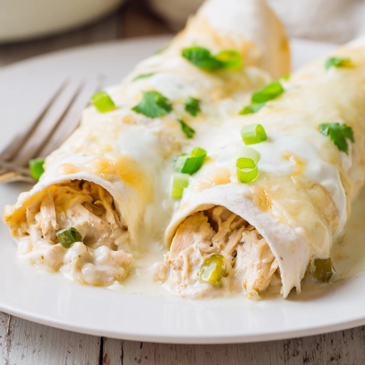 Fresh from oven, Creamy White Chicken Enchiladas topped with sour cream.