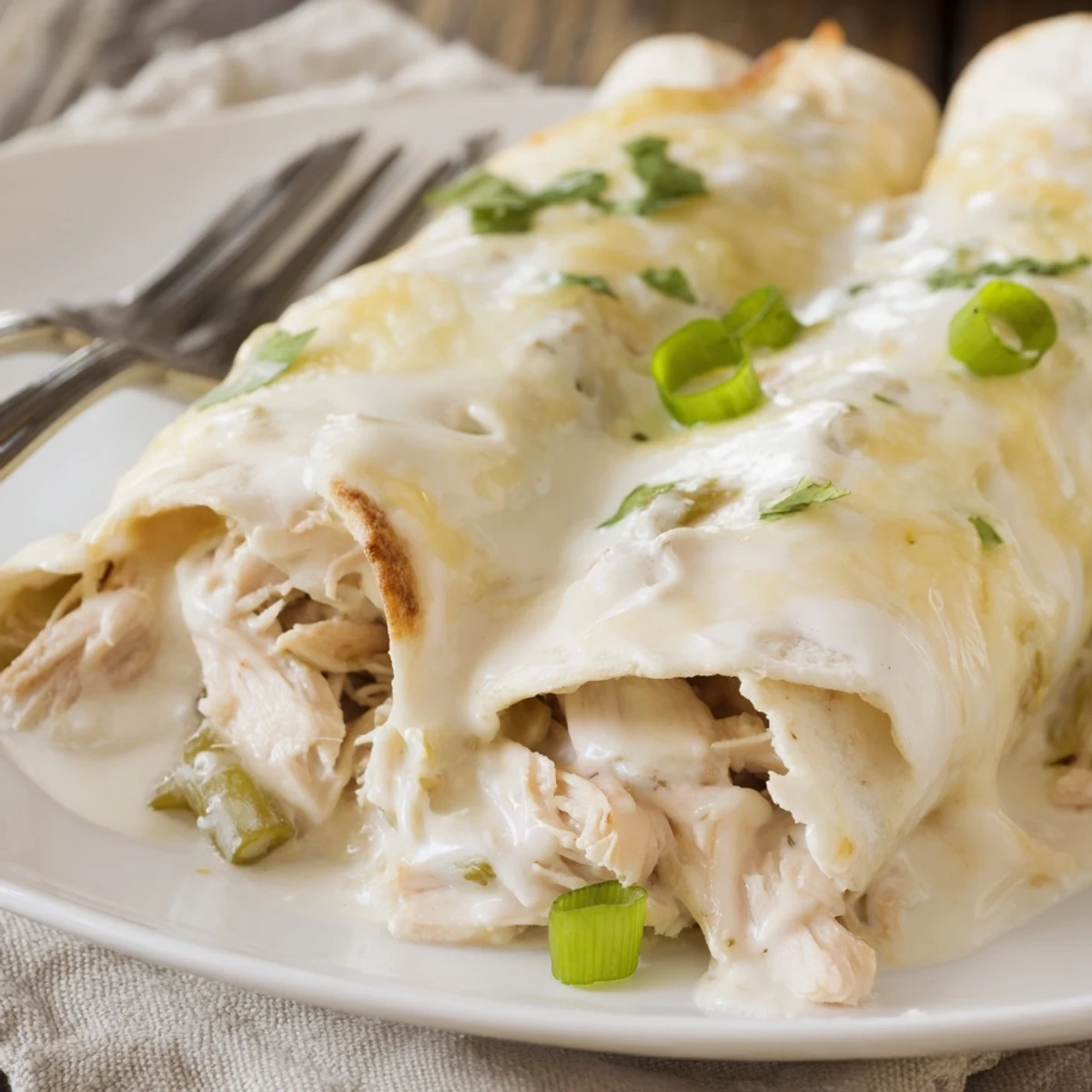 Stacked Creamy White Chicken Enchiladas in a baking dish, velvety sauce sheen.