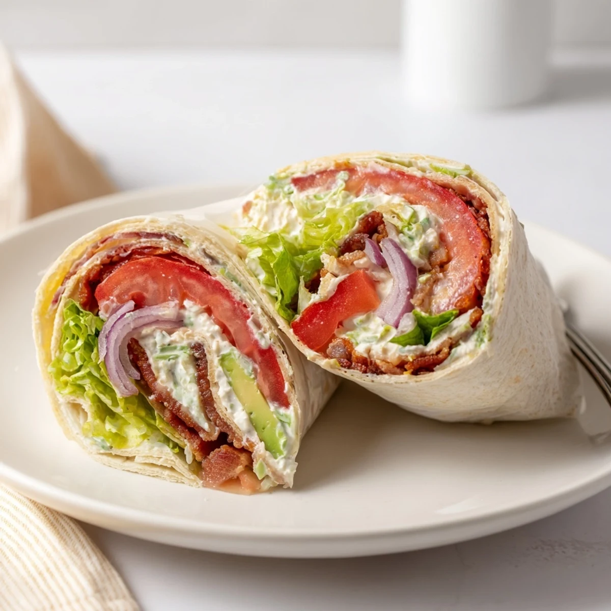 Stack of Meal Prep BLT Wraps wrapped in foil, perfect grab-and-go lunches