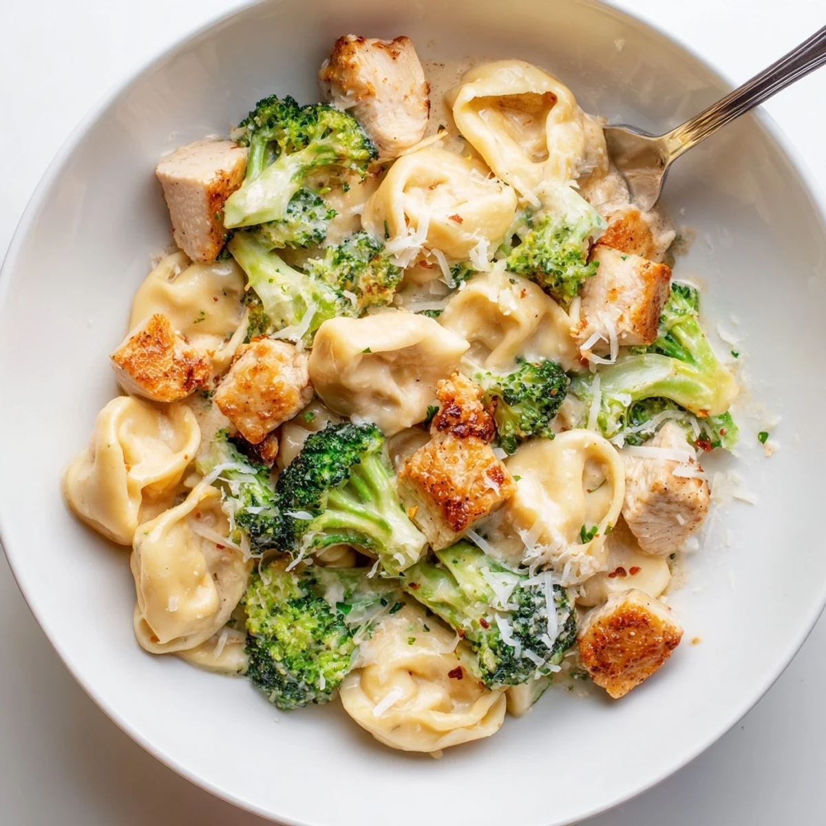 Creamy Garlic Parmesan Tortellini Chicken Broccoli Recipe steaming, saucy pasta with golden chicken