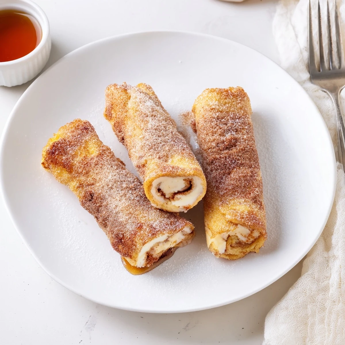 Cinnamon Roll French Toast Roll Ups, golden brown and warmly spiced, served with syrup