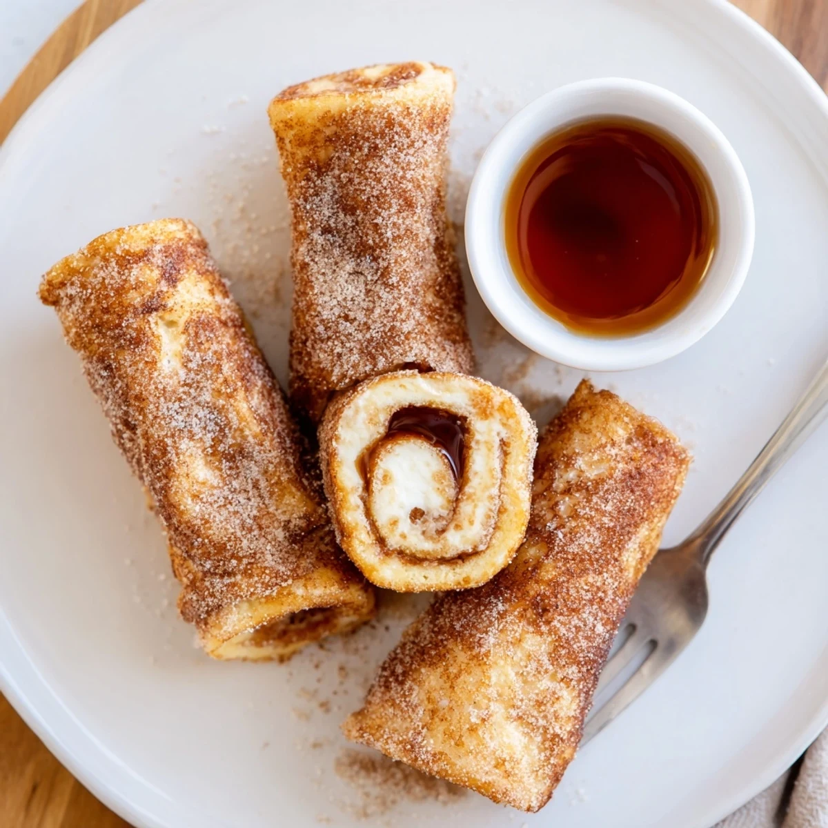 Warm Cinnamon Roll French Toast Roll Ups handheld, cream cheese oozing gently