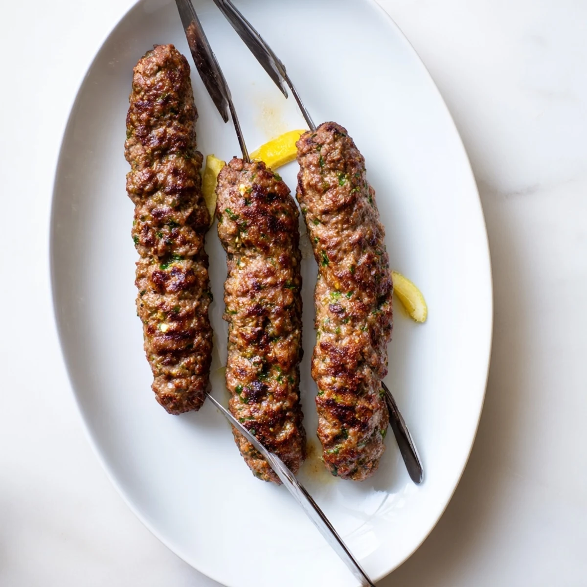 Golden grilled Lamb Kofta Kebabs on metal skewers with fresh herbs and char marks