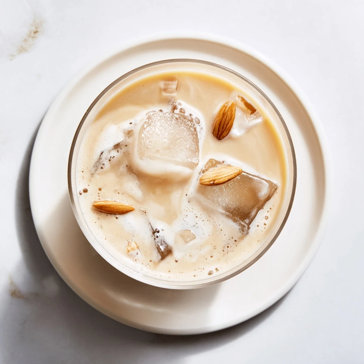 Creamy refreshing summer roasted almond milk beverage served over ice with floating almond slivers