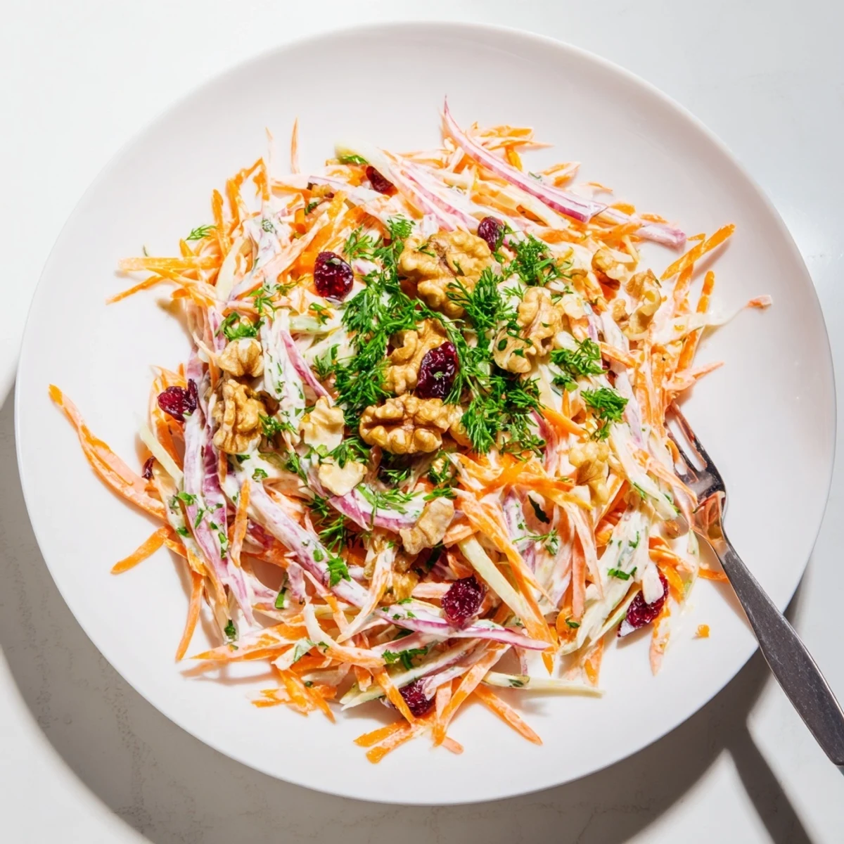 Crisp apple carrot slaw with shredded vegetables coated in creamy tangy yogurt dressing