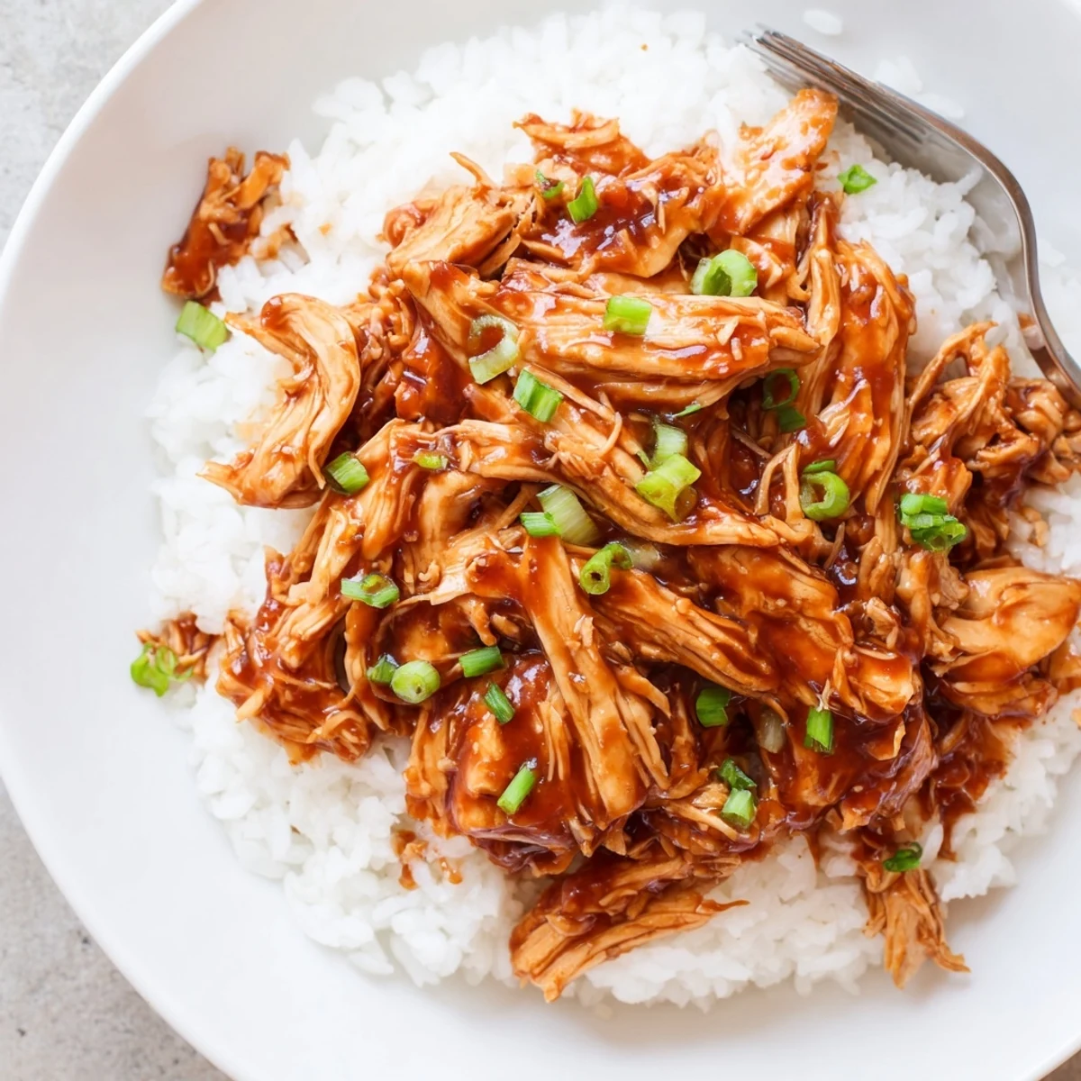 Crockpot Honey Garlic Chicken glazed in sticky sauce over steaming white rice