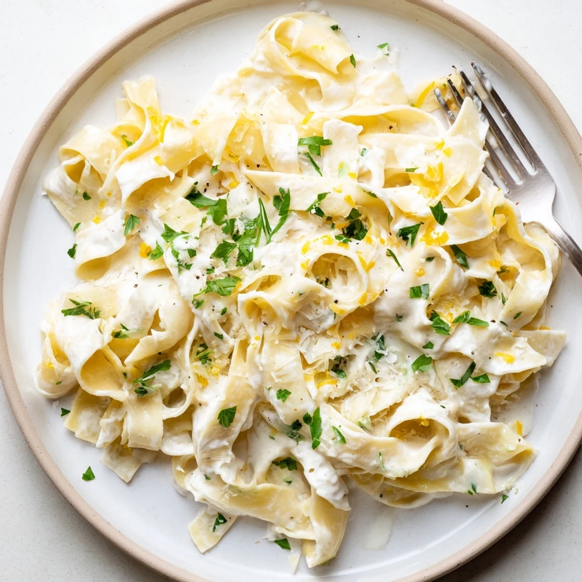 Golden creamy cafeteria noodles tossed in rich Parmesan sauce, garnished with fresh green parsley