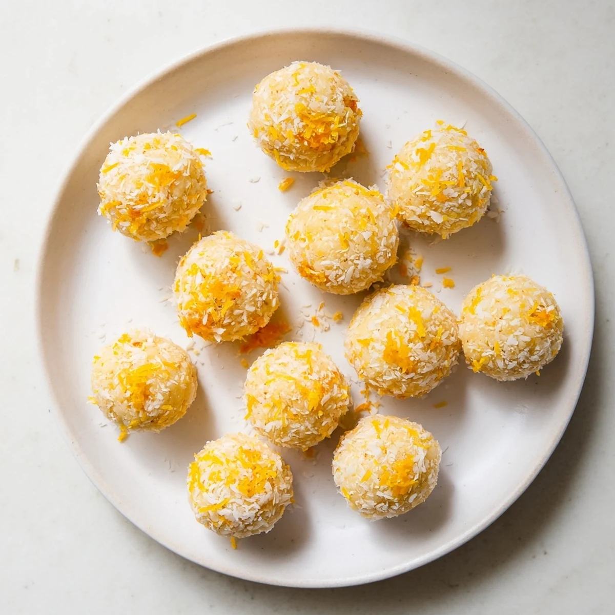 Citrus Bliss Bites arranged on a white platter with fresh orange slices and lemon wedges