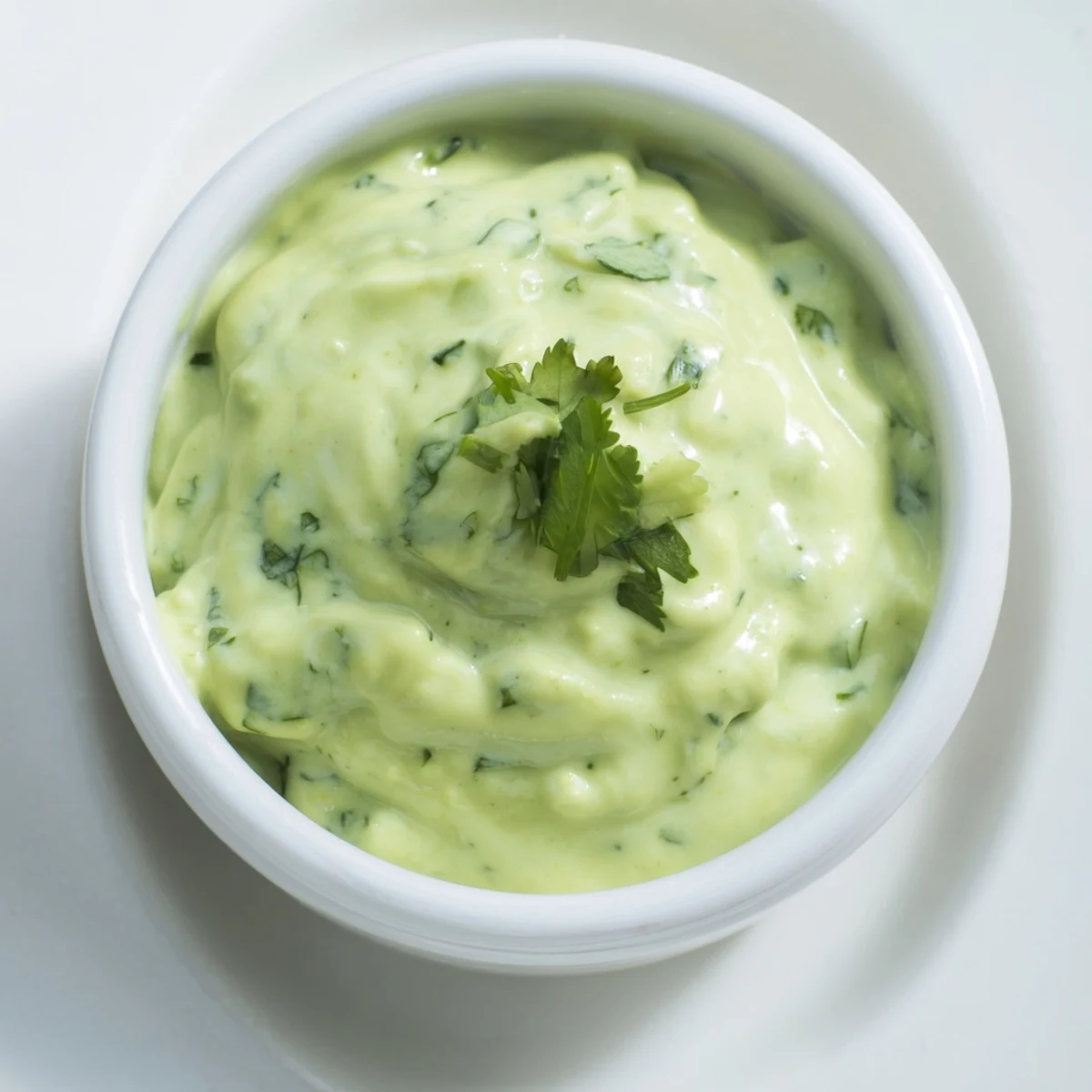 Vibrant green creamy cilantro lime sauce drizzled over grilled chicken tacos with fresh lime wedges