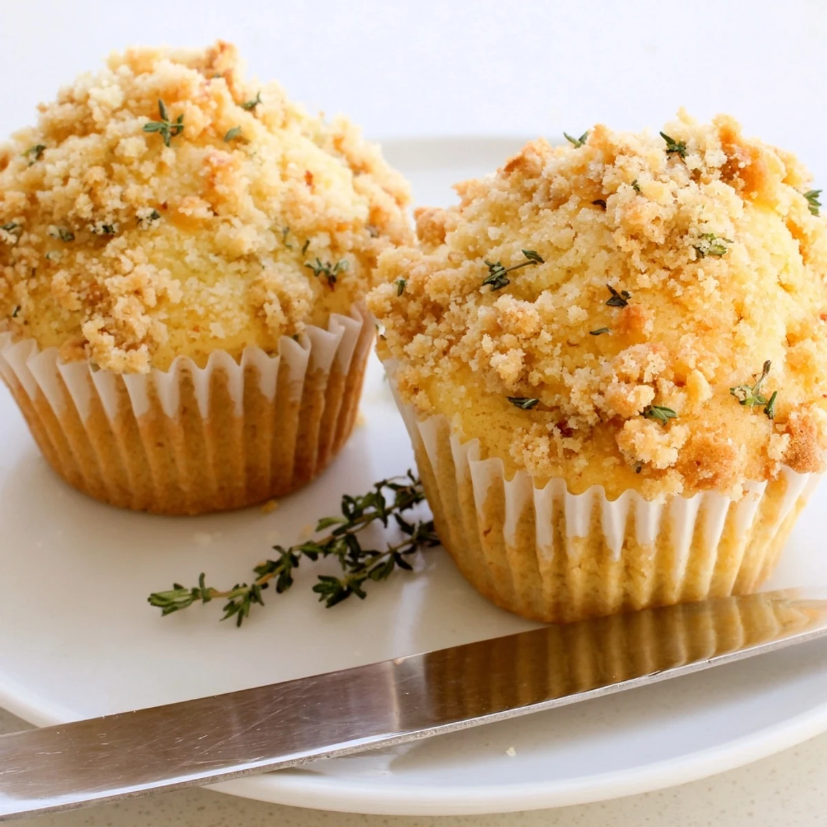 Lemon orange honey muffins topped with herbaceous thyme crumble on a rustic plate