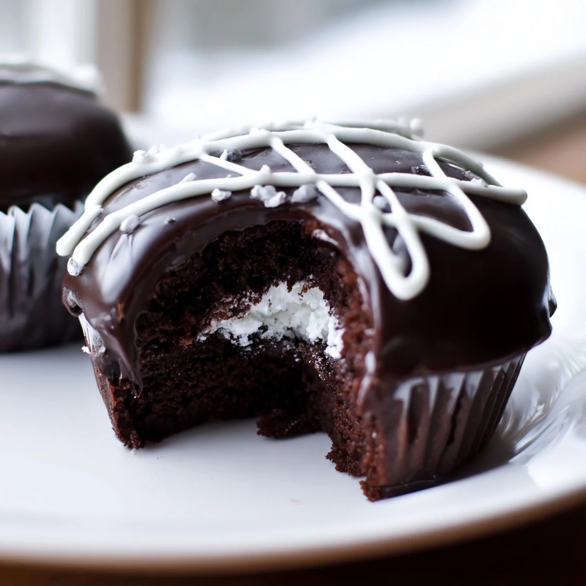Homemade Hostess Cupcakes with glossy chocolate ganache and signature white icing swirl