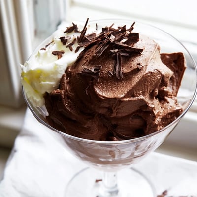 Silky chocolate mousse with airy whipped cream dollops in dessert cups